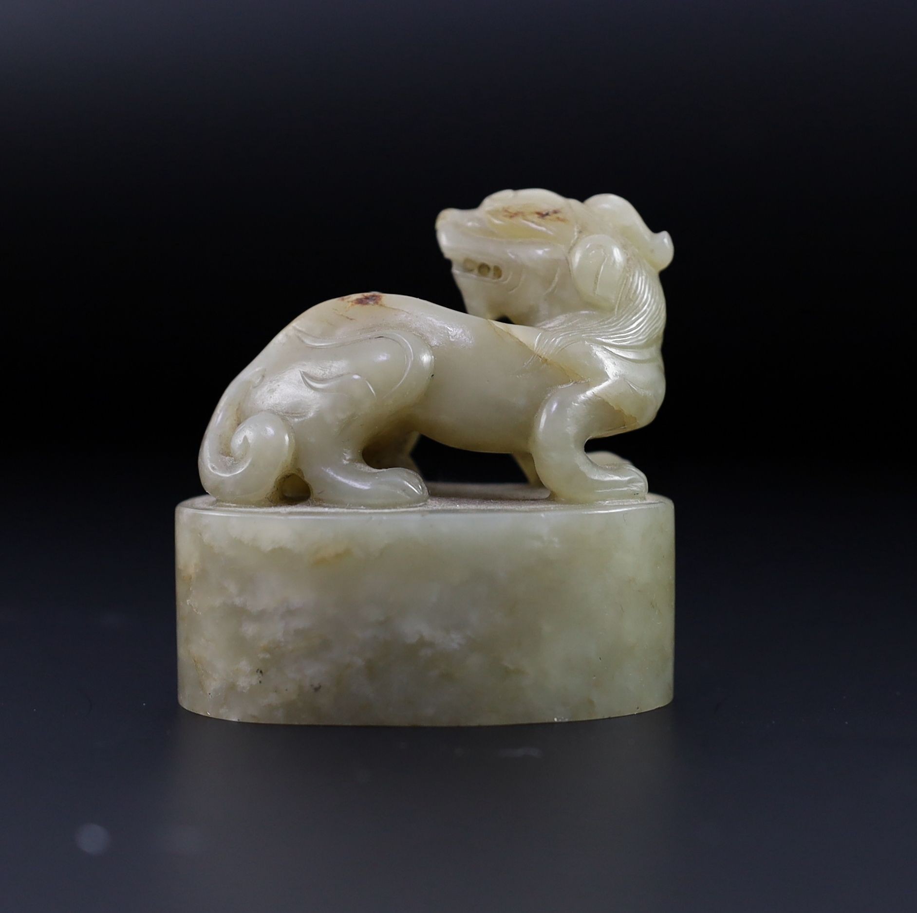 A Chinese celadon and white mottled jade ‘lion-dog’ seal, 18th/19th century, 6cm long